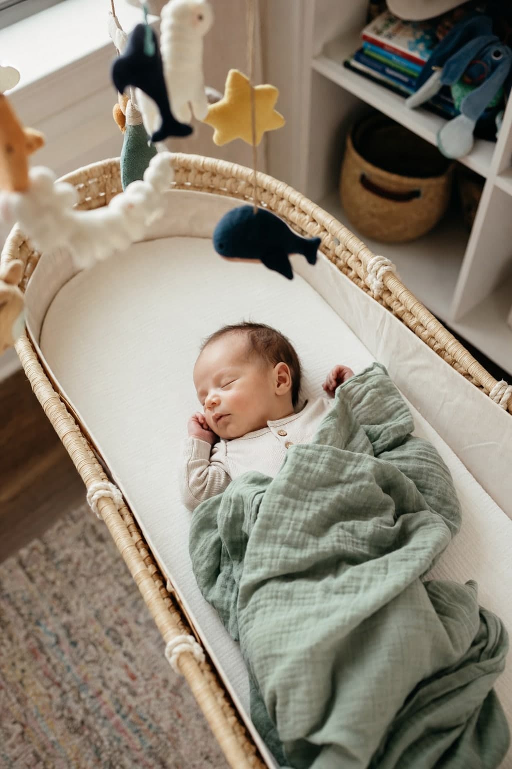 A sleeping newborn wrapped in a swaddle in a bassinet